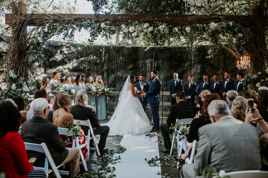 Elegant outdoor wedding ceremony with vows and floral arch