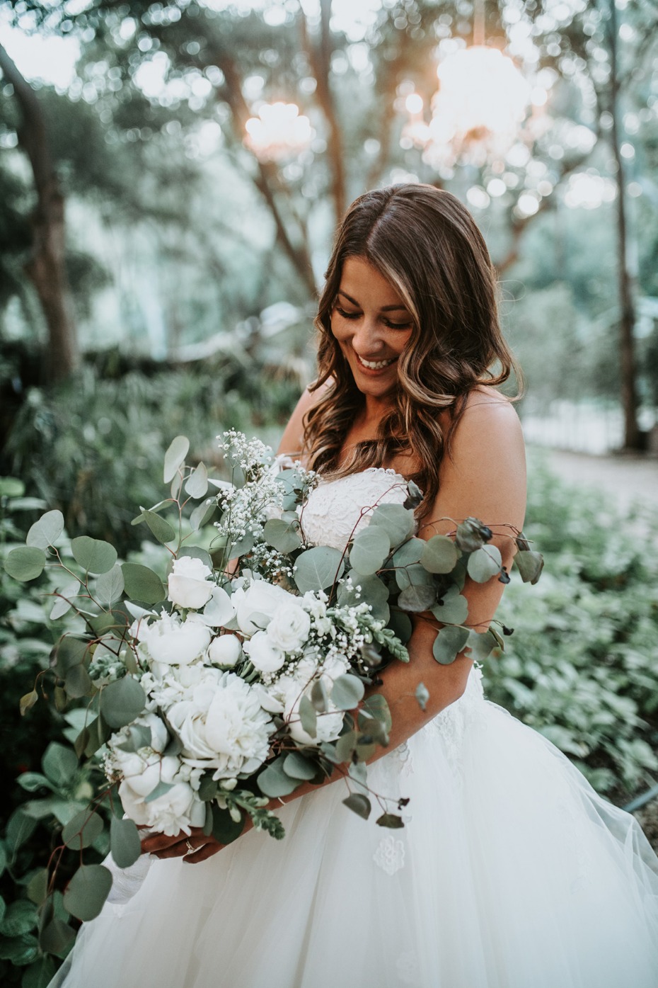 Smiling bride in a wedding dress holds a beautiful bouquet