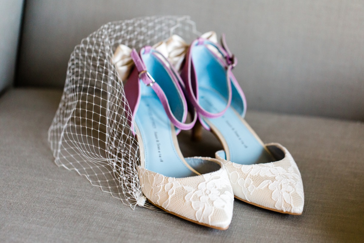 Elegant white lace wedding shoes with purple and blue details