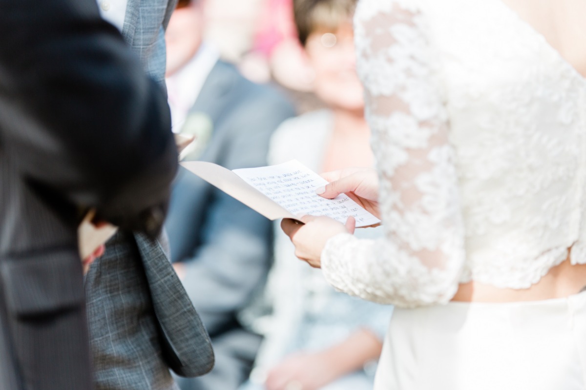 Bride holding vows during a wedding ceremony, close-up shot