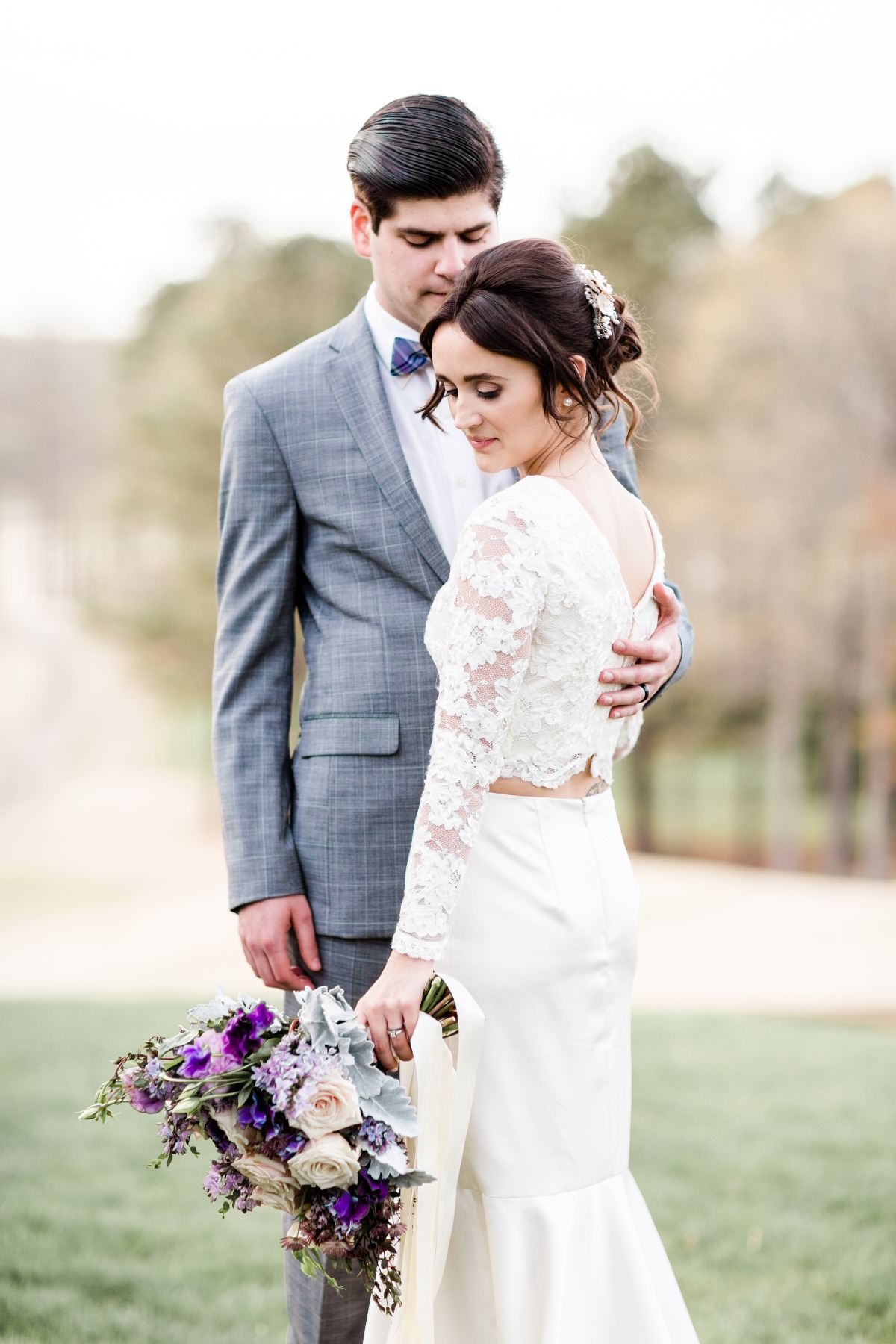 Romantic bride and groom embrace with wedding bouquet