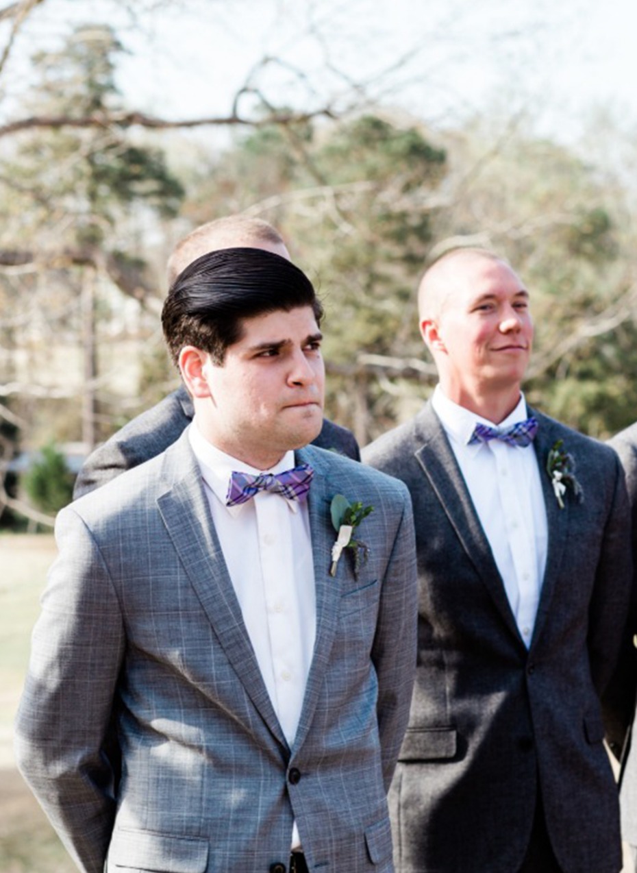 Groomsmen in grey suits at outdoor wedding ceremony