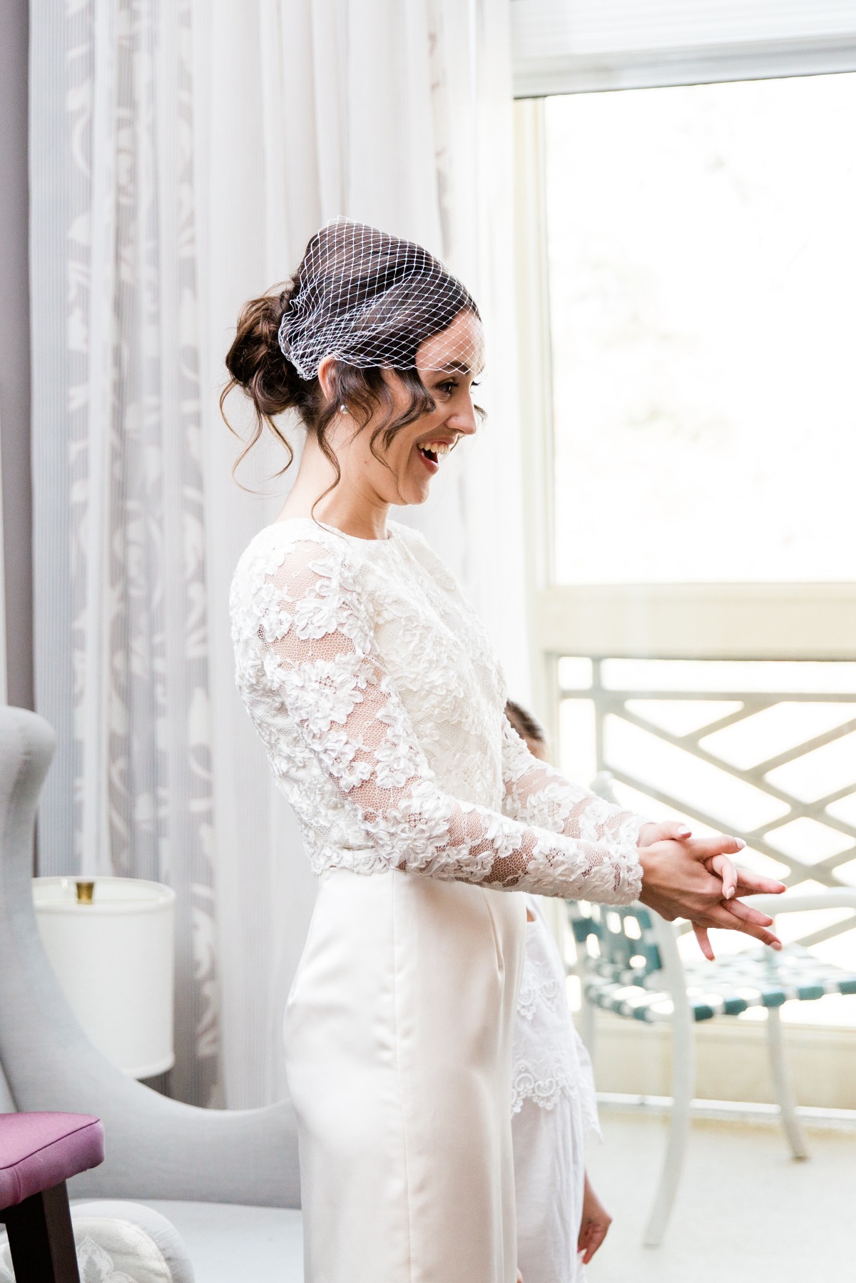 Joyful bride with lace top and veil clapping hands