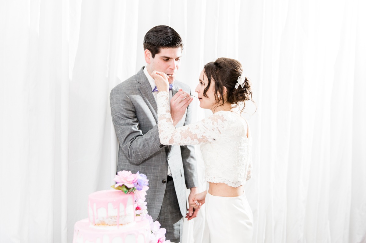 Bride and groom sharing wedding cake during the ceremony