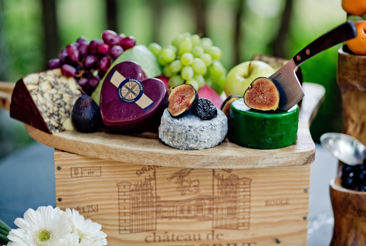 Elaborate cheese platter with figs grapes and cheese knife