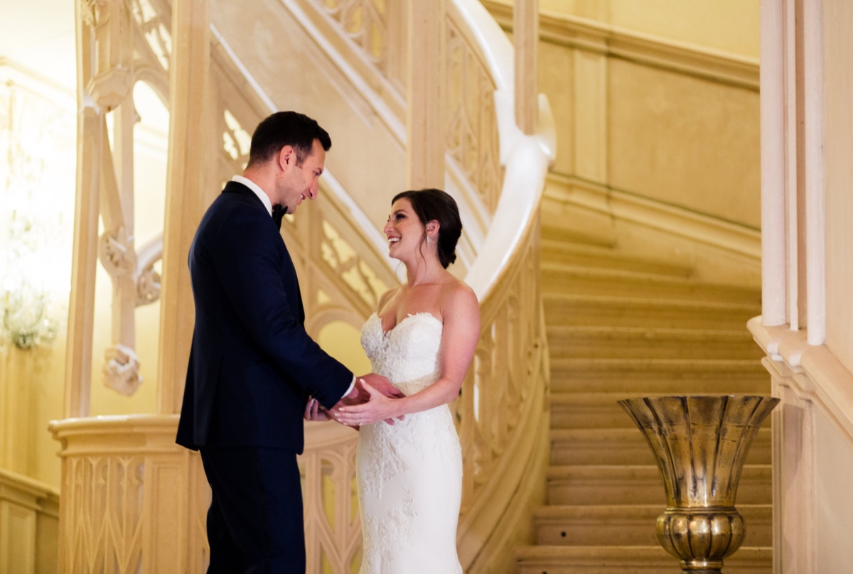 Happy bride and groom first look on grand staircase