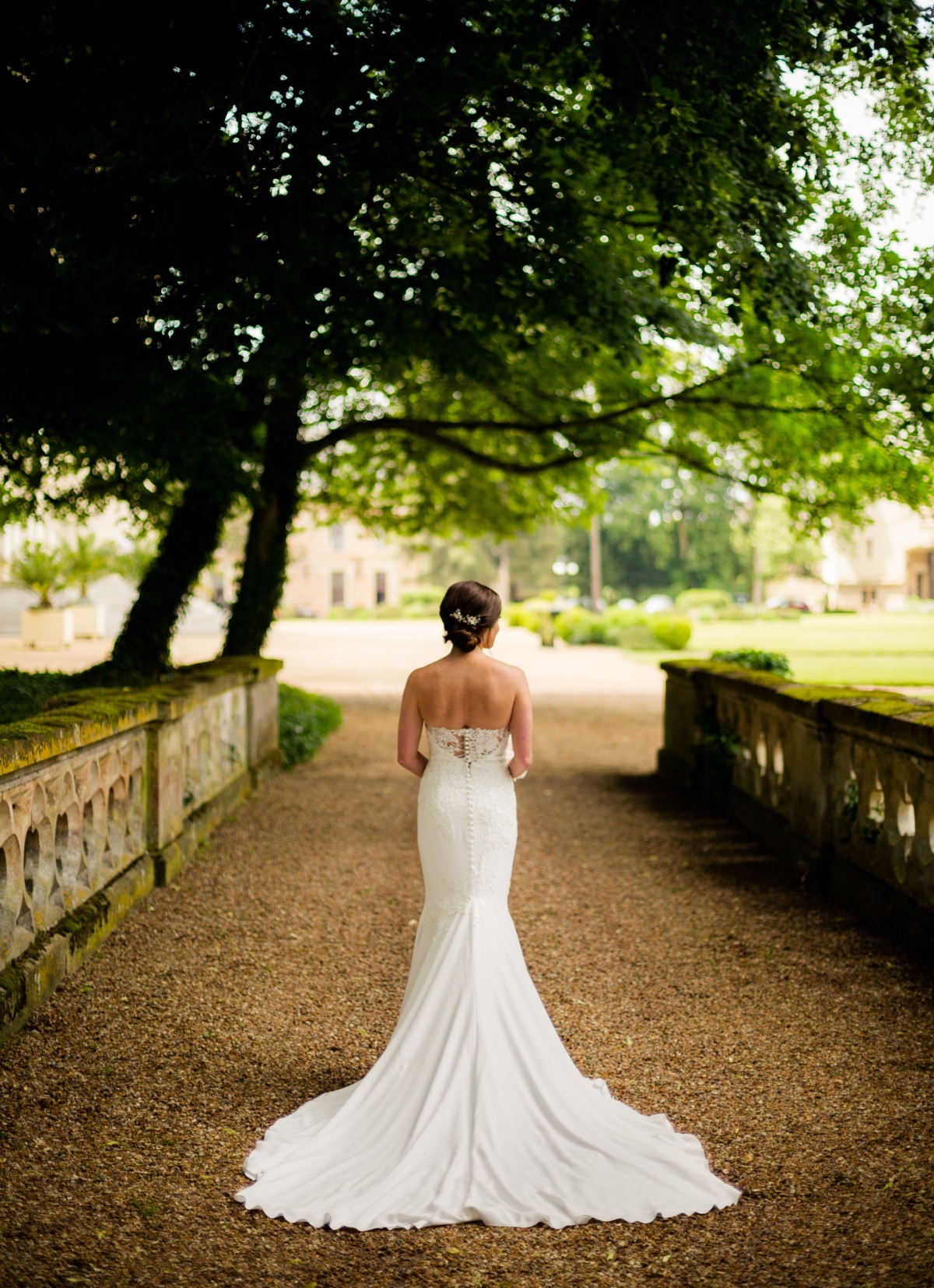 Bride in a white dress on a gravel path at wedding venue