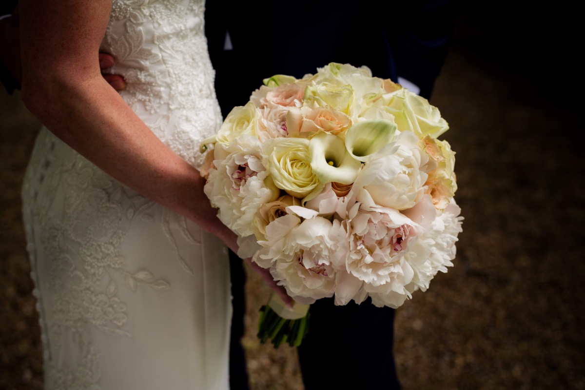 Bride holding white peach rose peony wedding bouquet