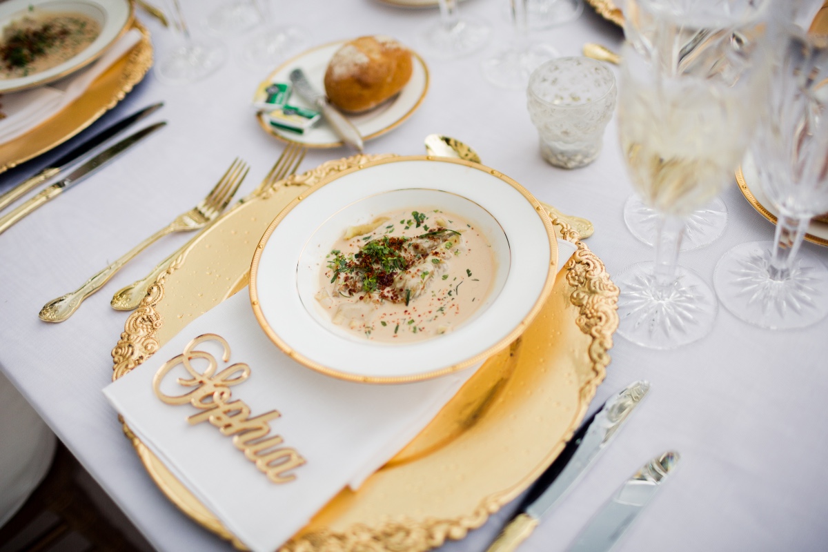 Elegant table setting with gold accents and a soup course