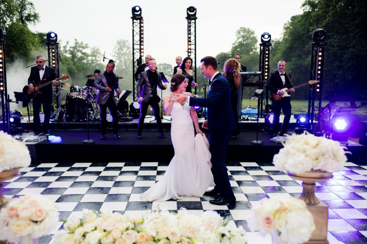 Bride and groom dance as band performs at outdoor wedding reception