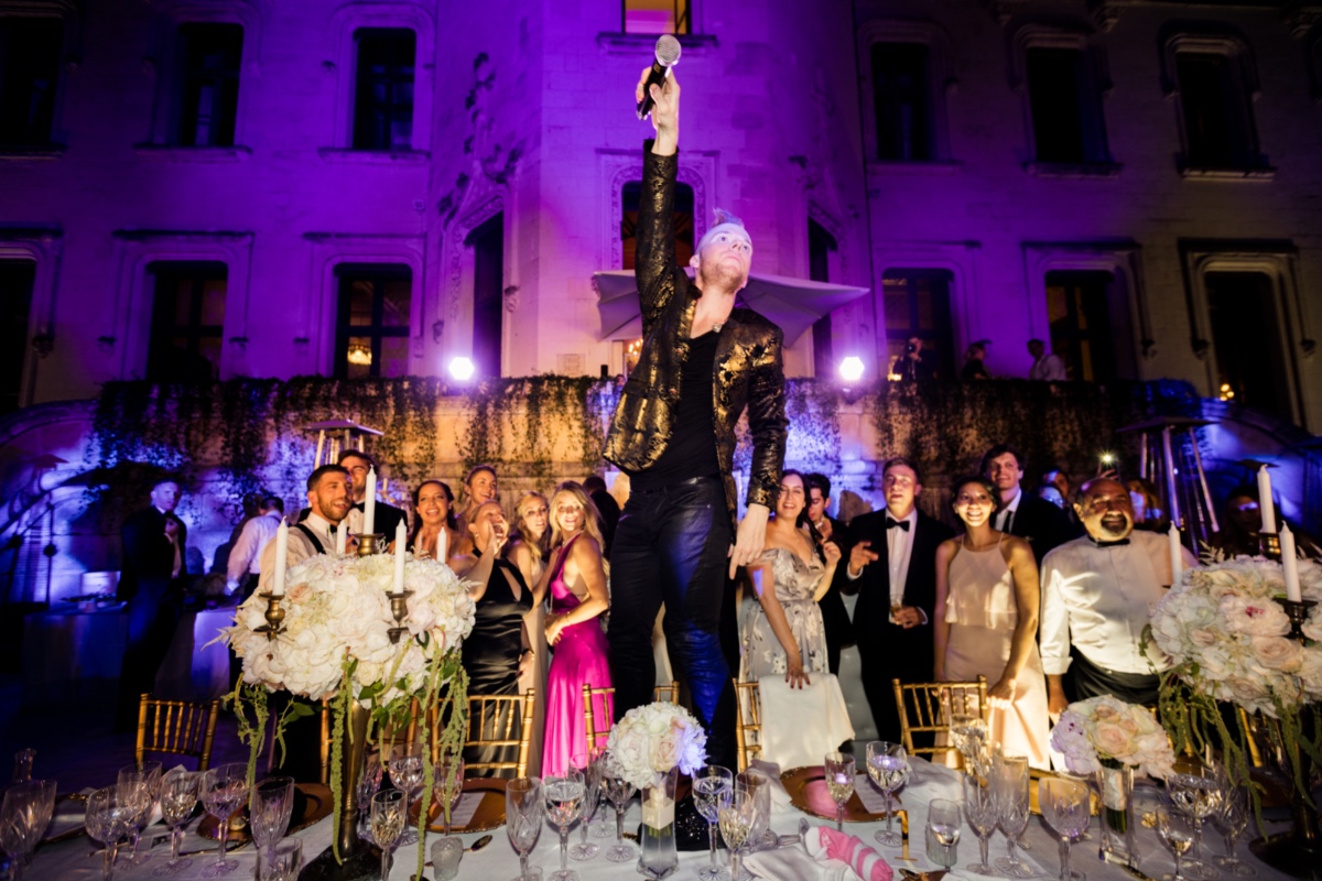Man with microphone celebrates at a wedding party with guests