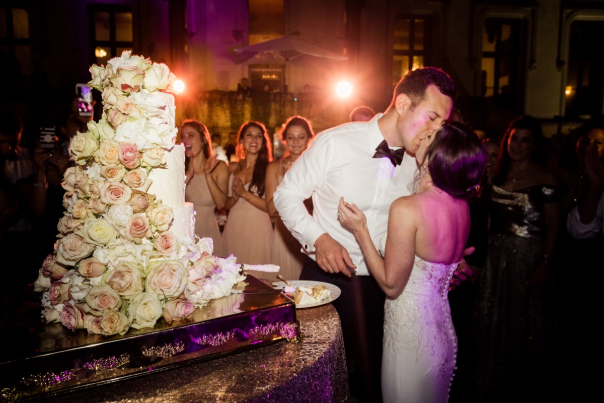 Newlyweds share a passionate kiss after cutting the beautiful wedding cake