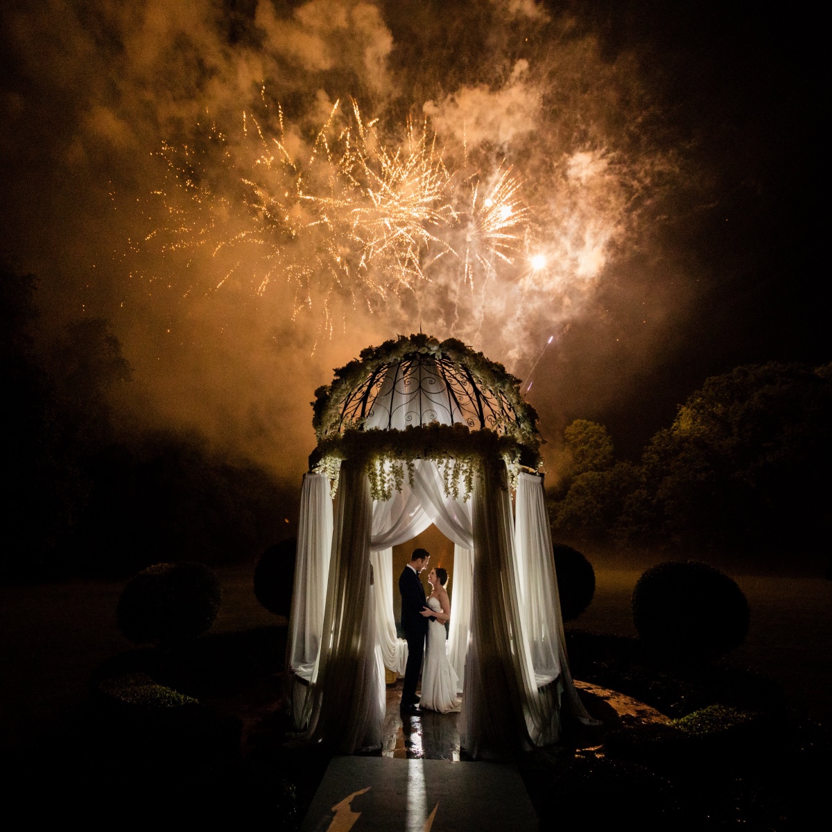 Couple under fireworks at wedding ceremony, romantic celebration