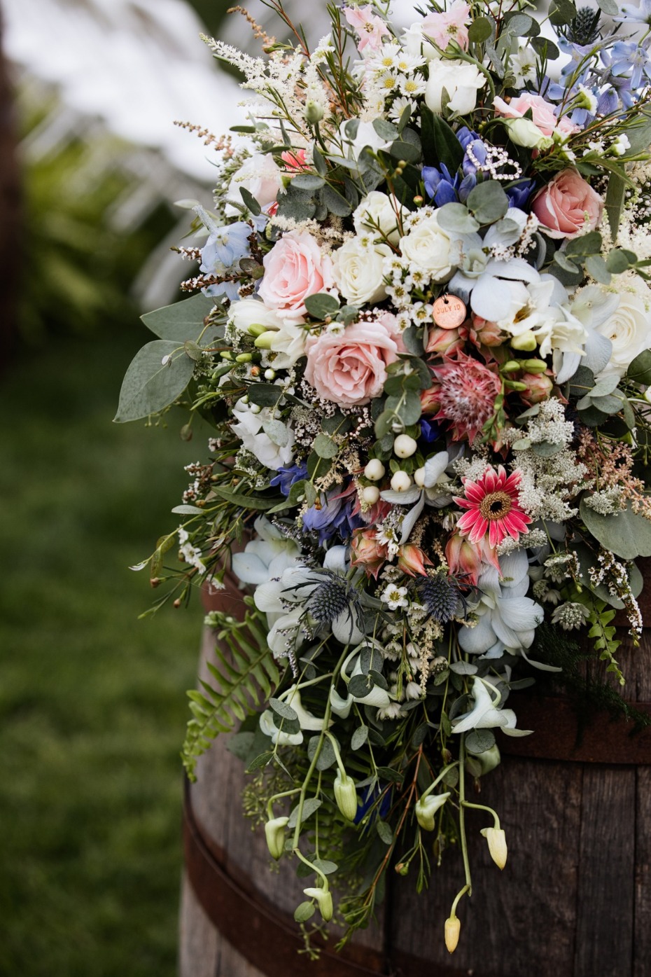 Stunning cascading wedding bouquet with pink, white, and blue flowers