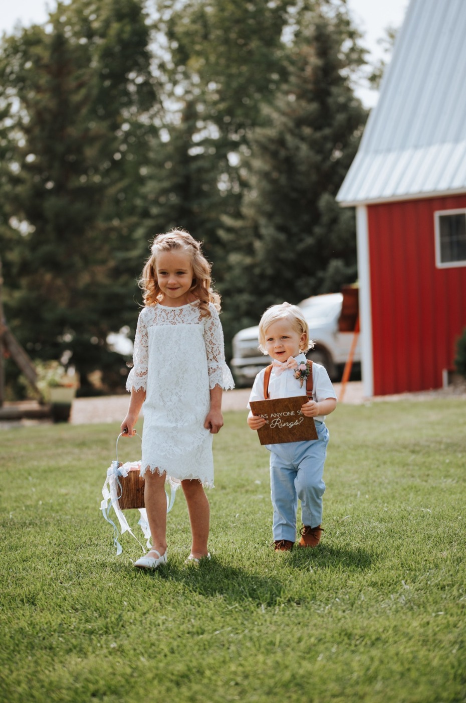 Adorable flower girl and ring bearer at barn wedding with sign