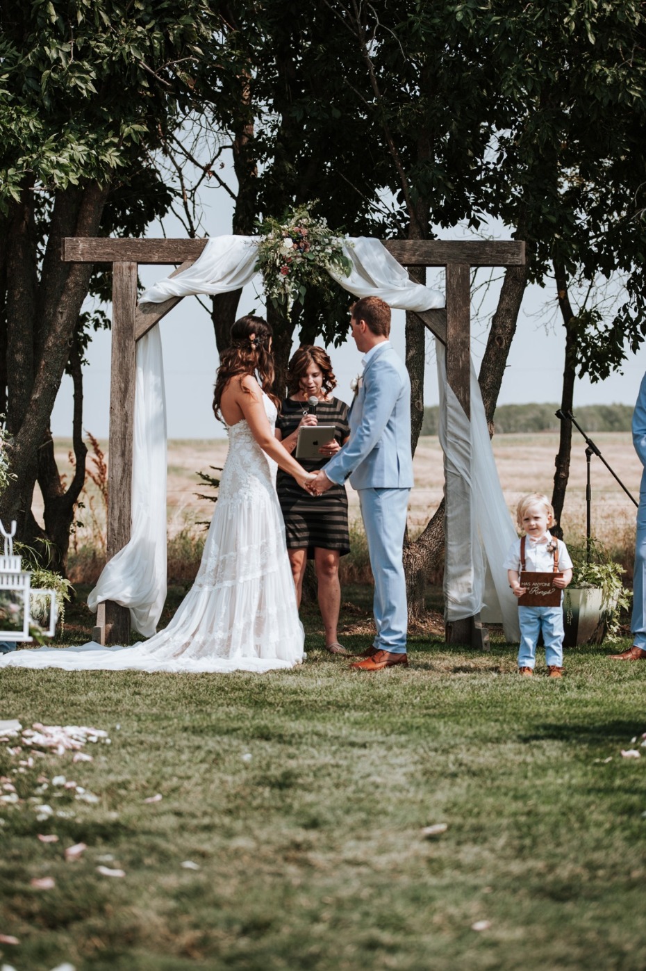 Bride and groom holding hands during an outdoor wedding ceremony