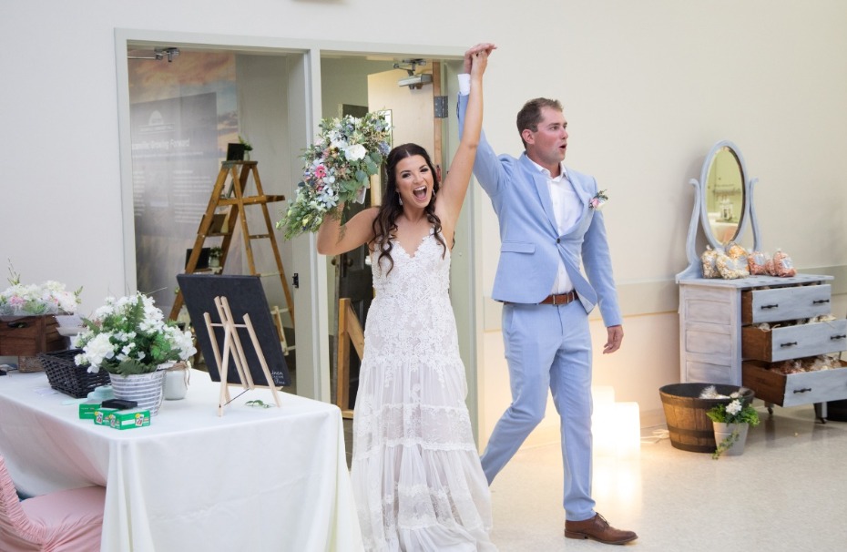 Happy bride and groom joyfully enter wedding reception