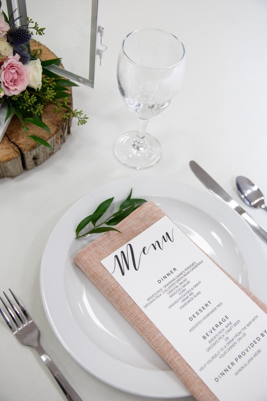 Elegant wedding table setting with menu, flowers, and wine glass