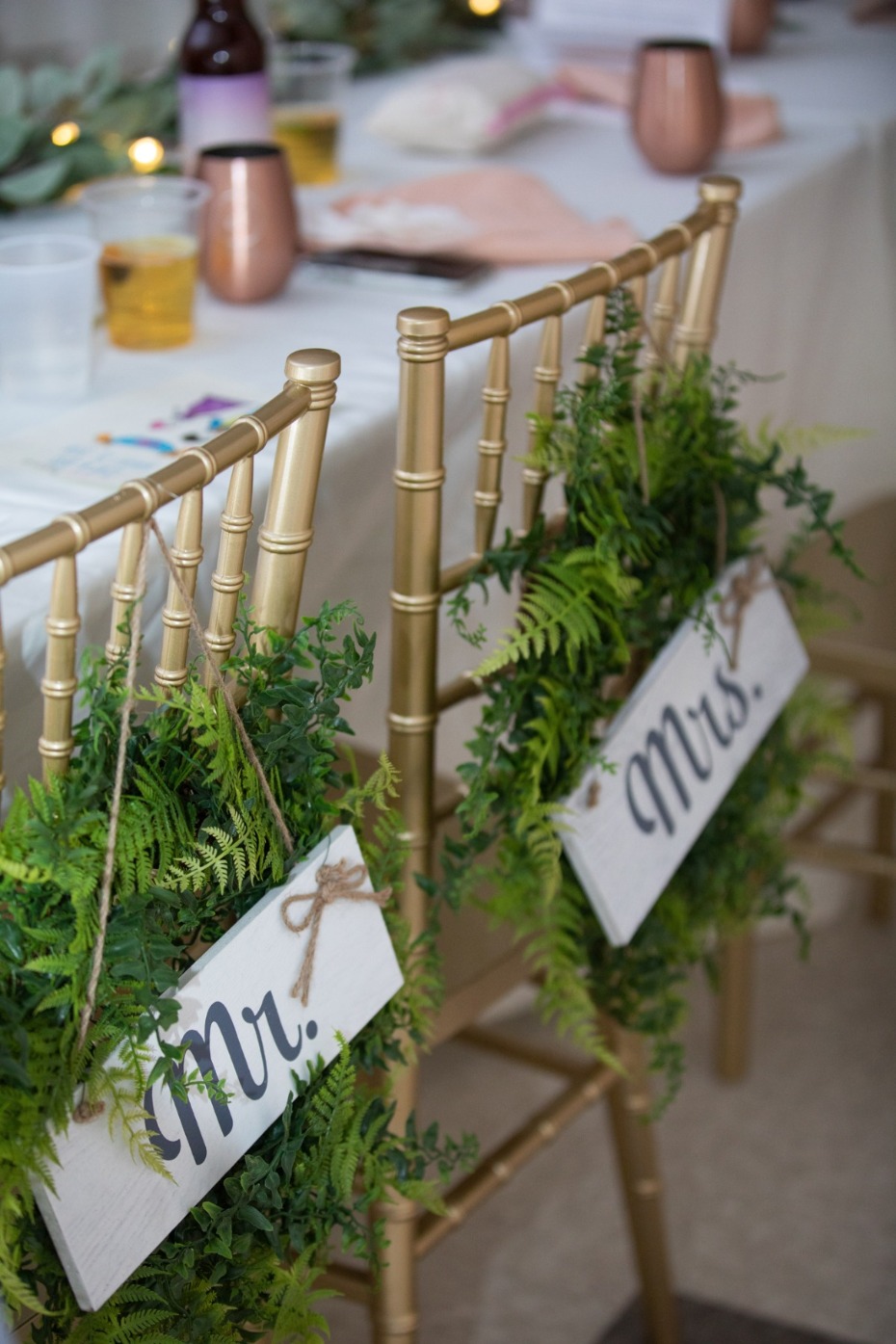 Wedding chairs decorated with greenery and Mr & Mrs signs