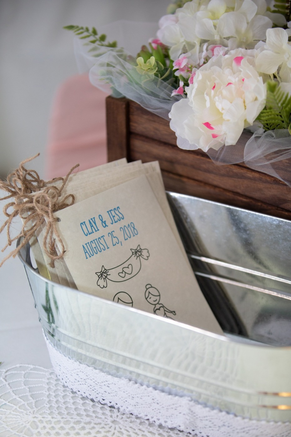 Wedding programs in rustic galvanized tub with flowers