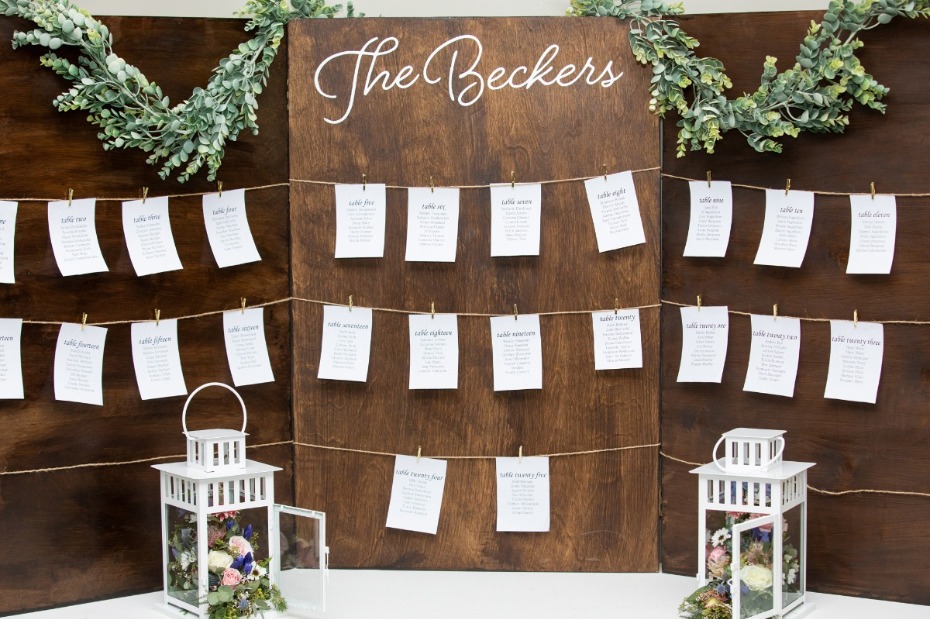 Rustic wedding seating chart with lanterns and floral decorations