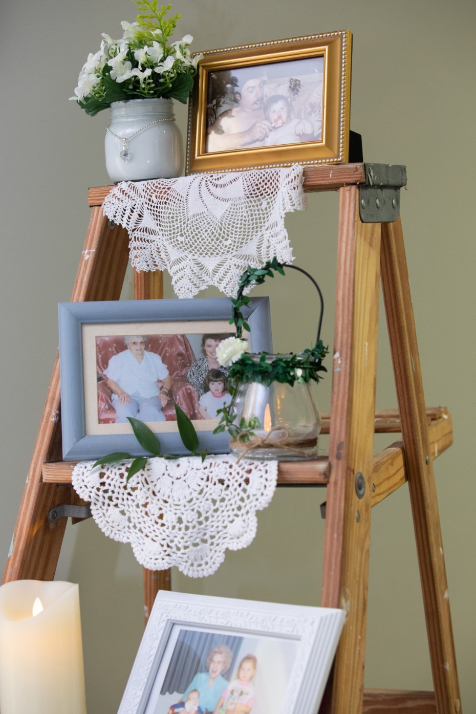 Rustic ladder decor with family photos flowers and lace