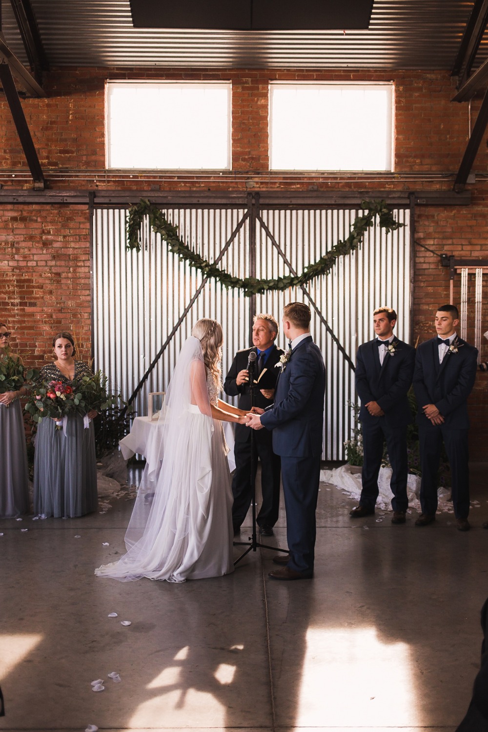 Bride and groom exchanging vows at rustic wedding ceremony