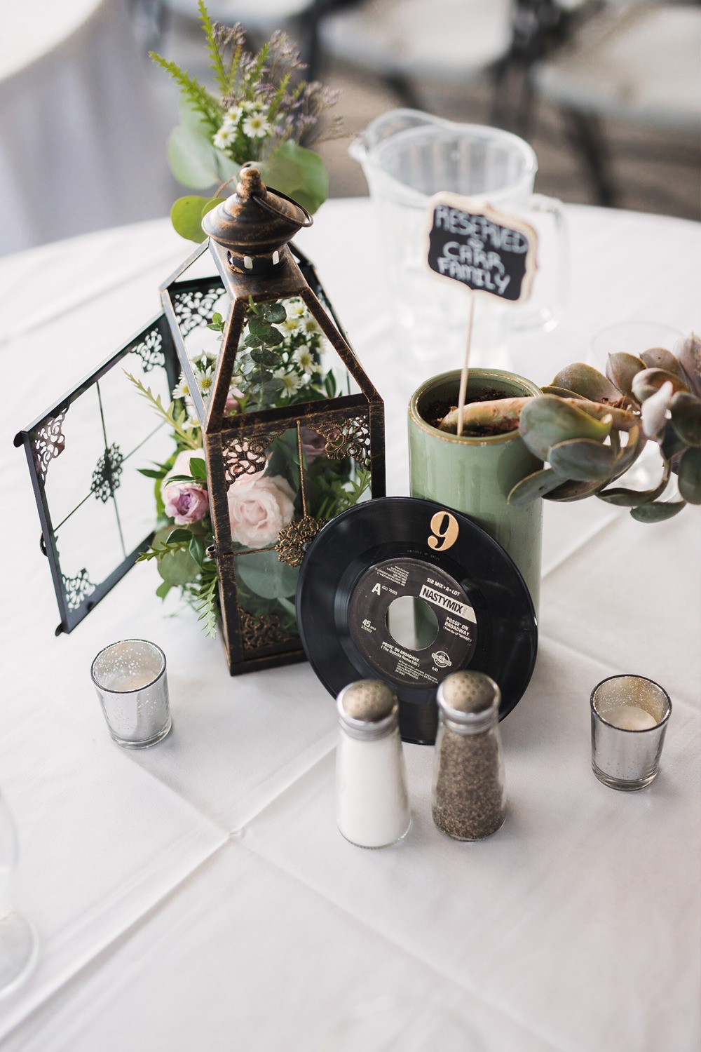 Wedding table setting with vintage lantern and record centerpiece