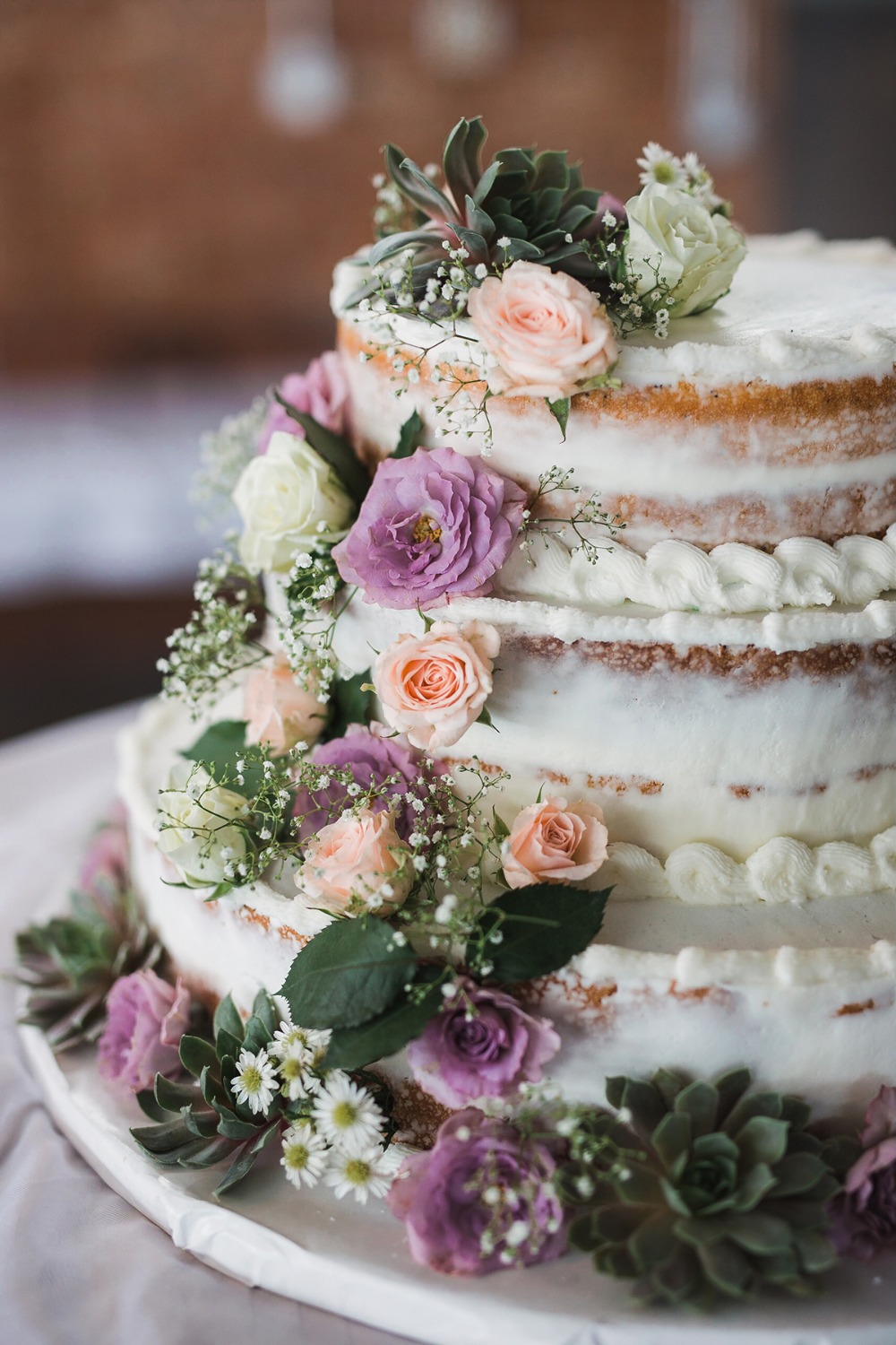 Elegant wedding cake with flowers and succulents beautifully decorated
