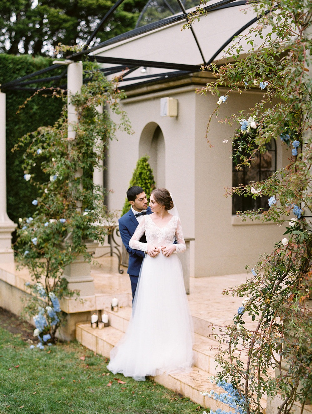 Elegant couple embraced at a wedding ceremony with beautiful flowers
