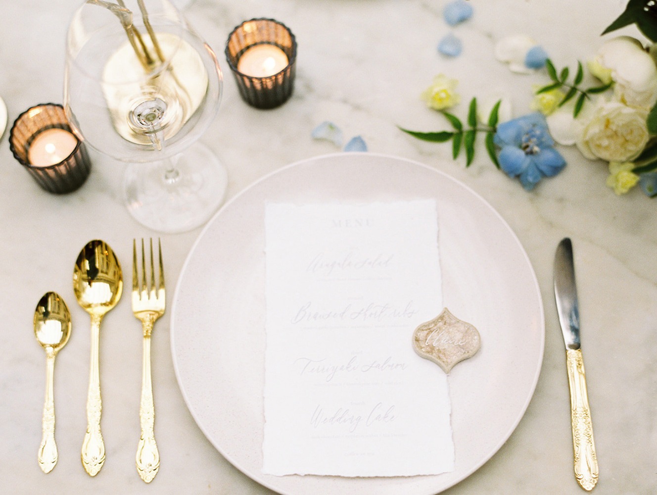 Elegant wedding table setting with gold cutlery and menu