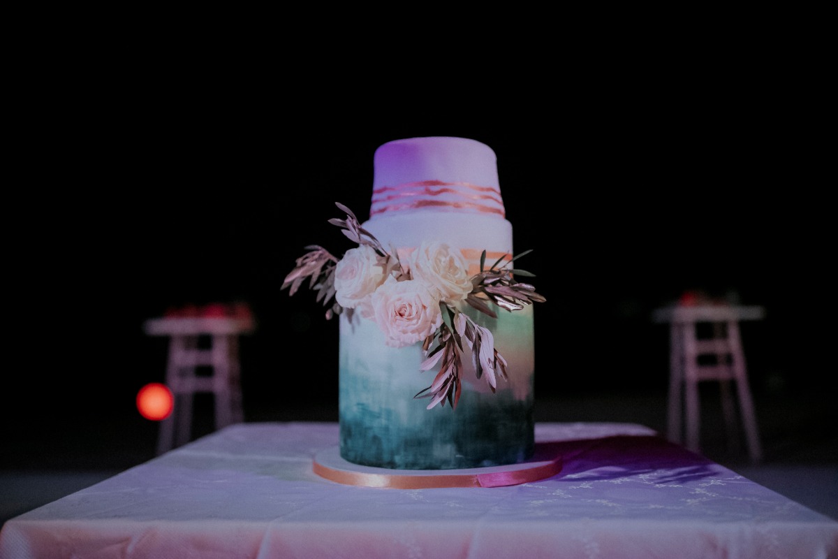 Elegant wedding cake with floral decorations on a table at night
