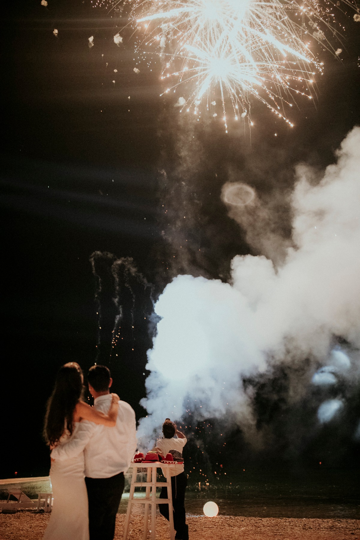 Couple watching fireworks on their wedding night celebration
