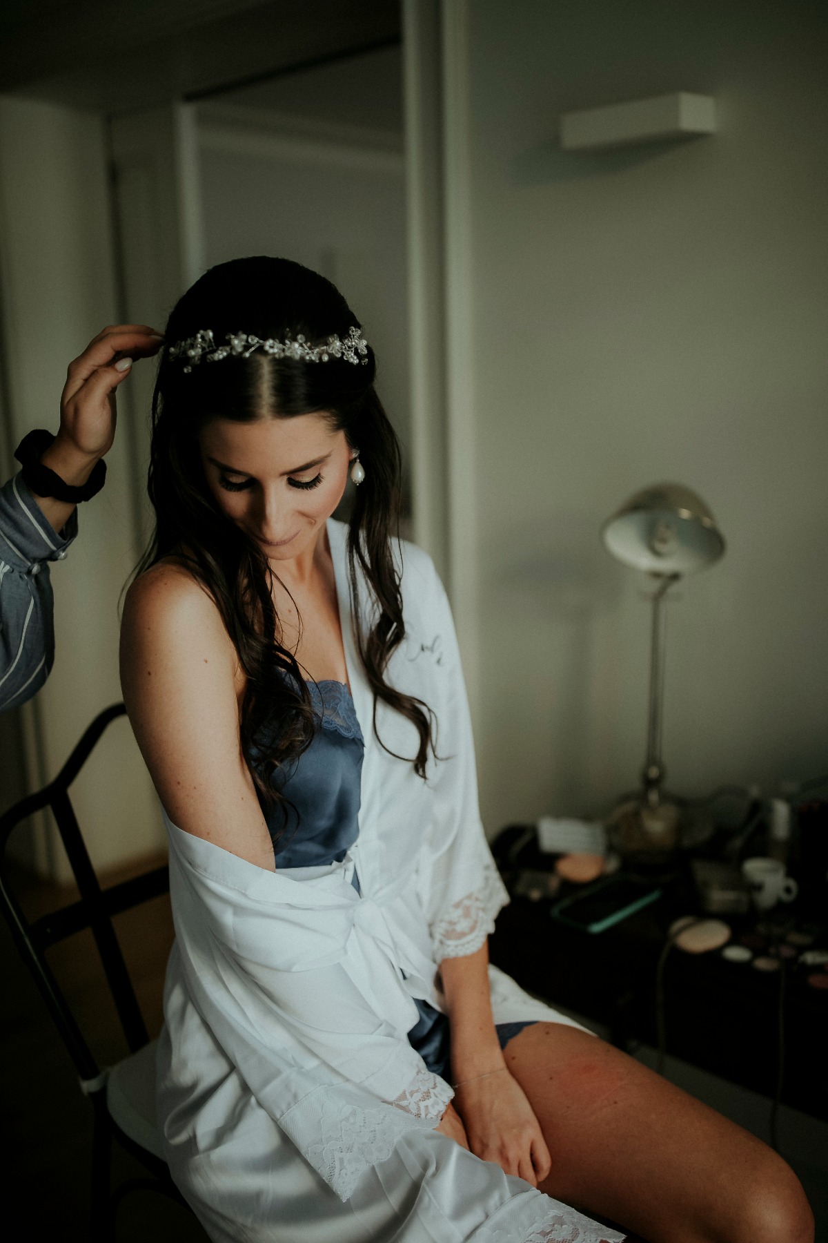 Bride getting ready with hair accessory and silk robe before wedding