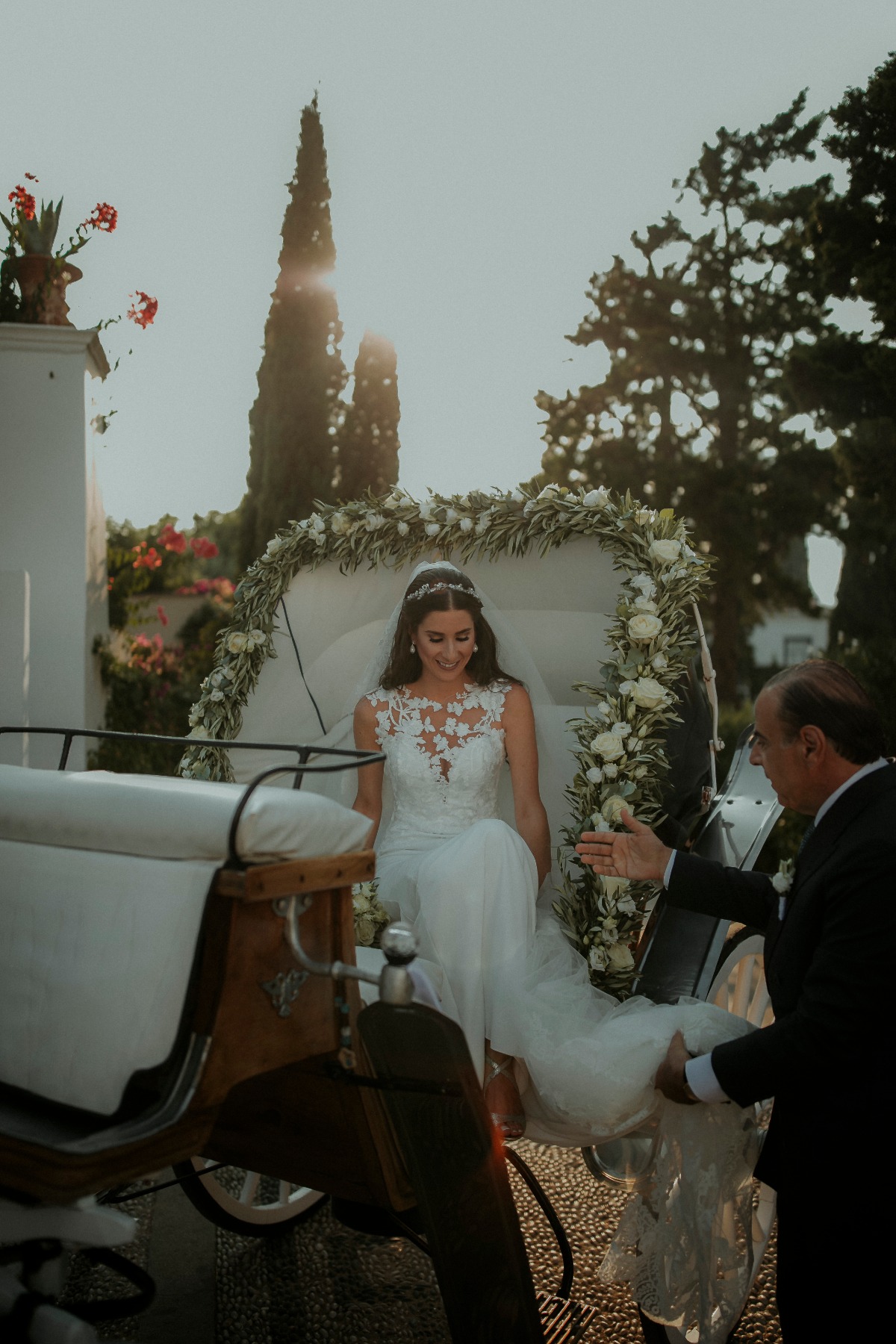 Beautiful bride steps from flower carriage on wedding day