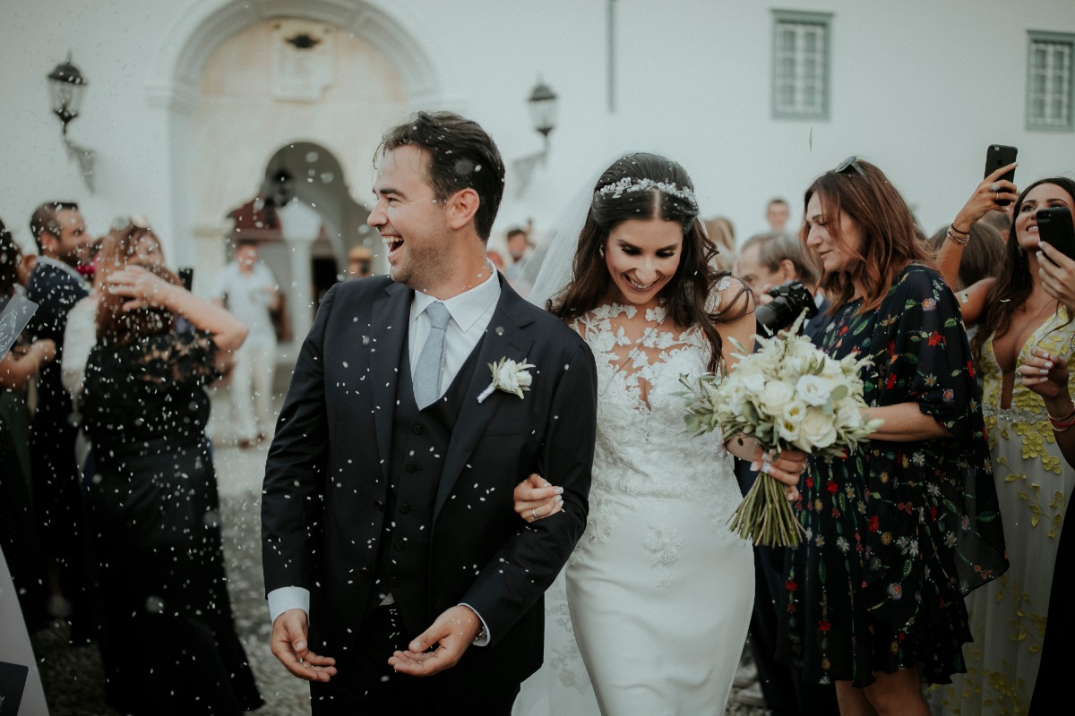 Happy bride and groom exit wedding confetti shower