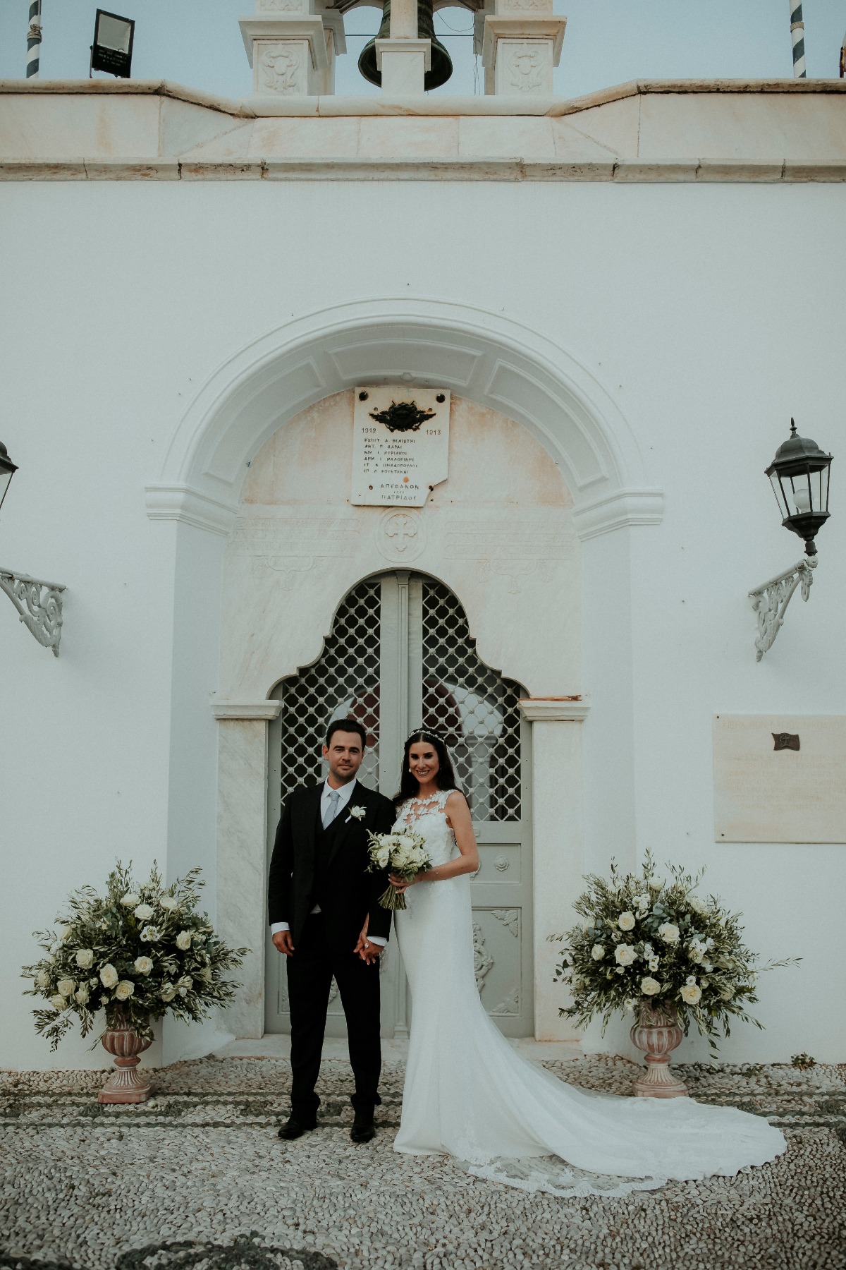 Bride and groom portrait white building flower vases