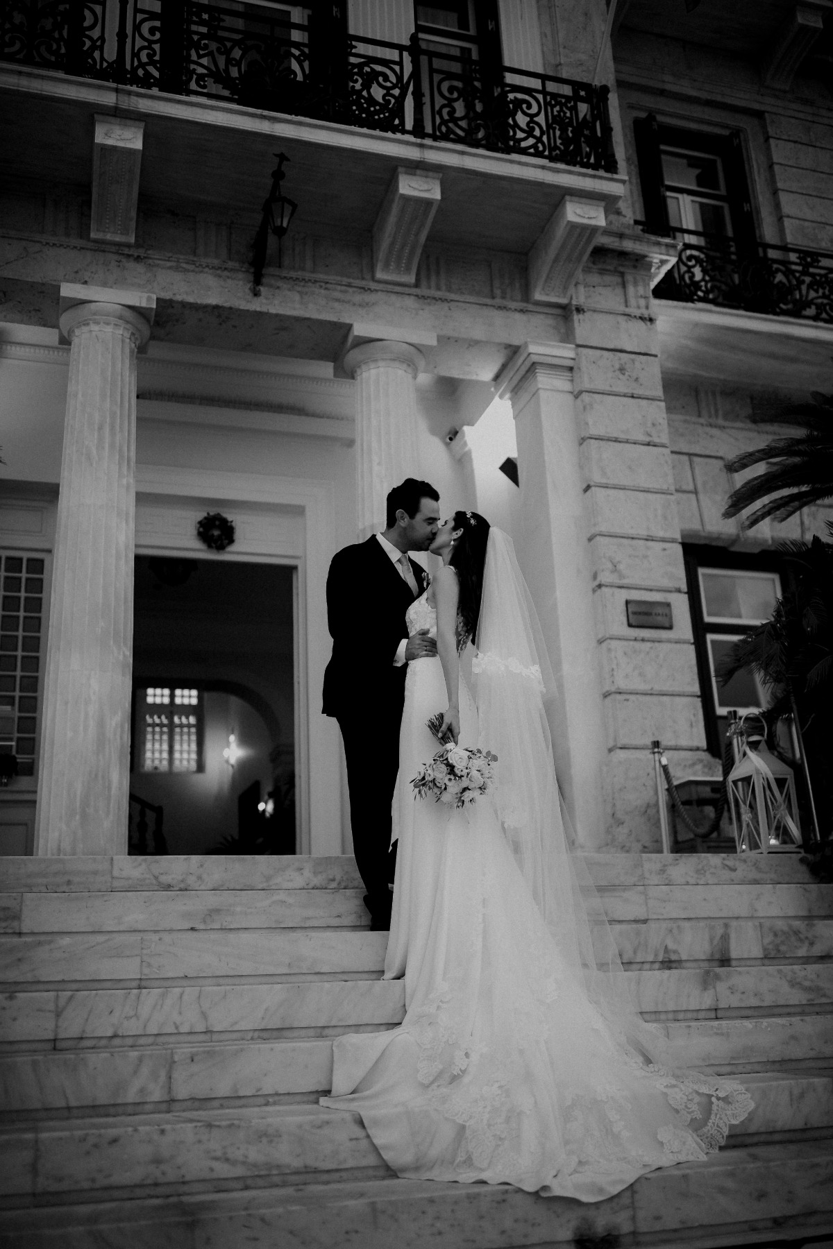 Romantic wedding kiss on grand marble building steps