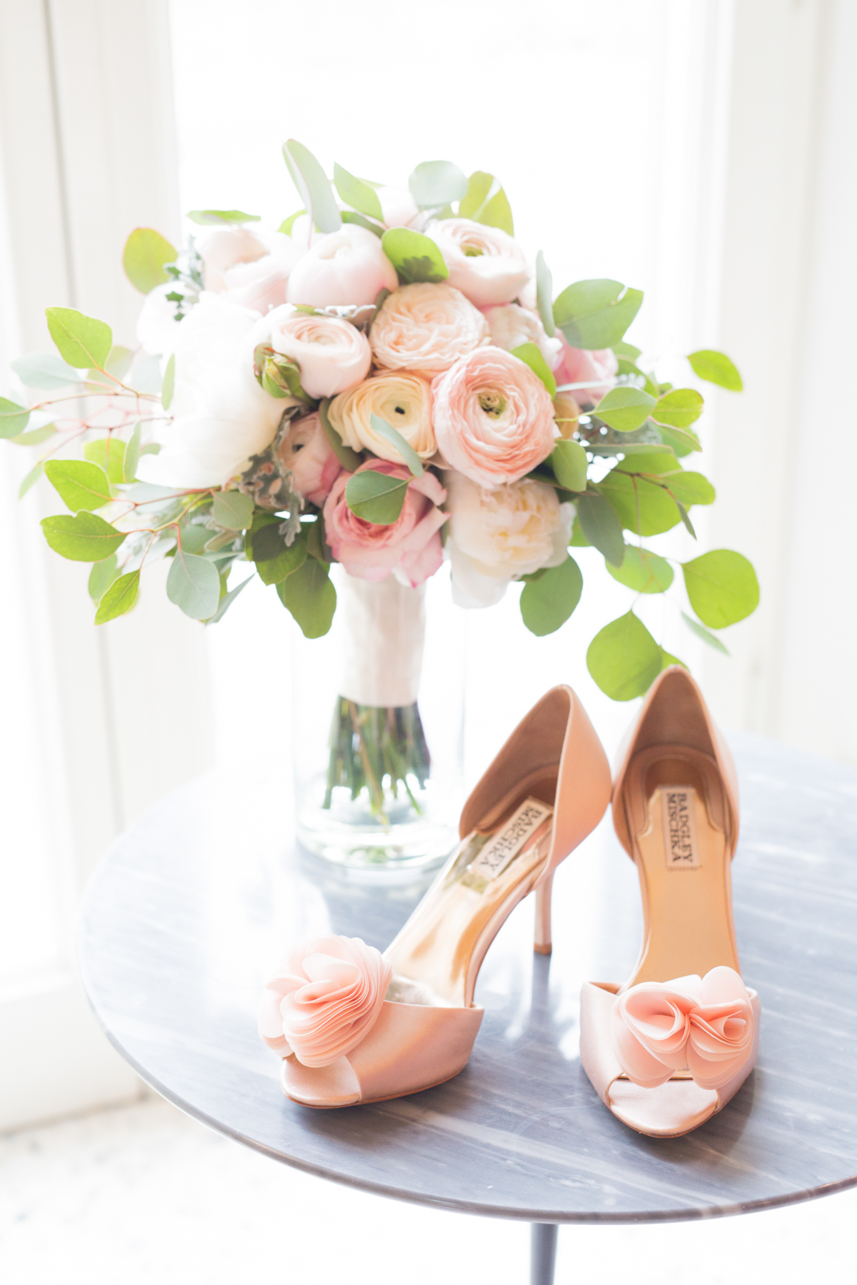 Elegant wedding bouquet and shoes on a marble table