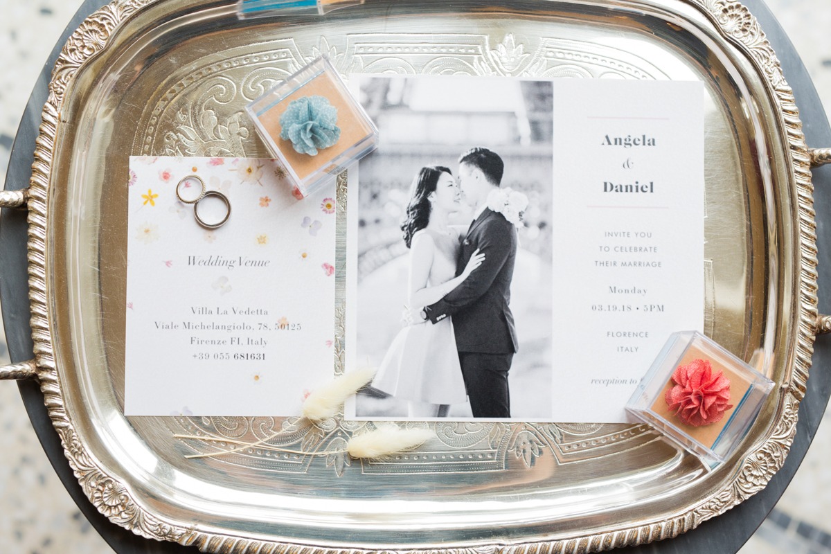 Elegant wedding invitation on silver tray with rings and flowers