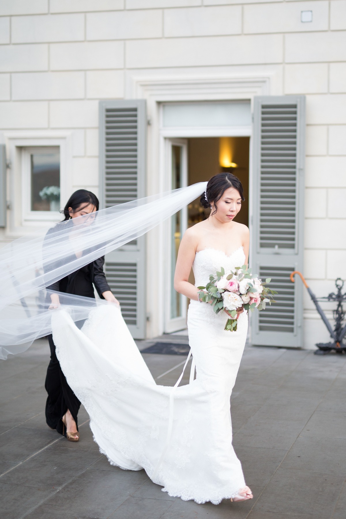 Beautiful bride with veil on her wedding day, holding flowers