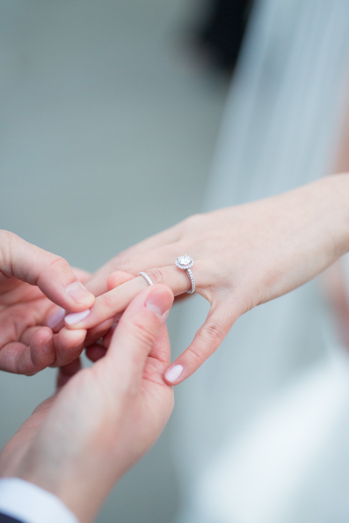 Groom placing wedding ring on brides finger during ceremony