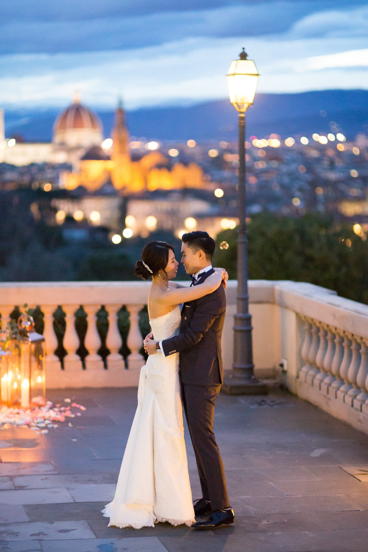 Romantic wedding couple in embrace with city lights in background