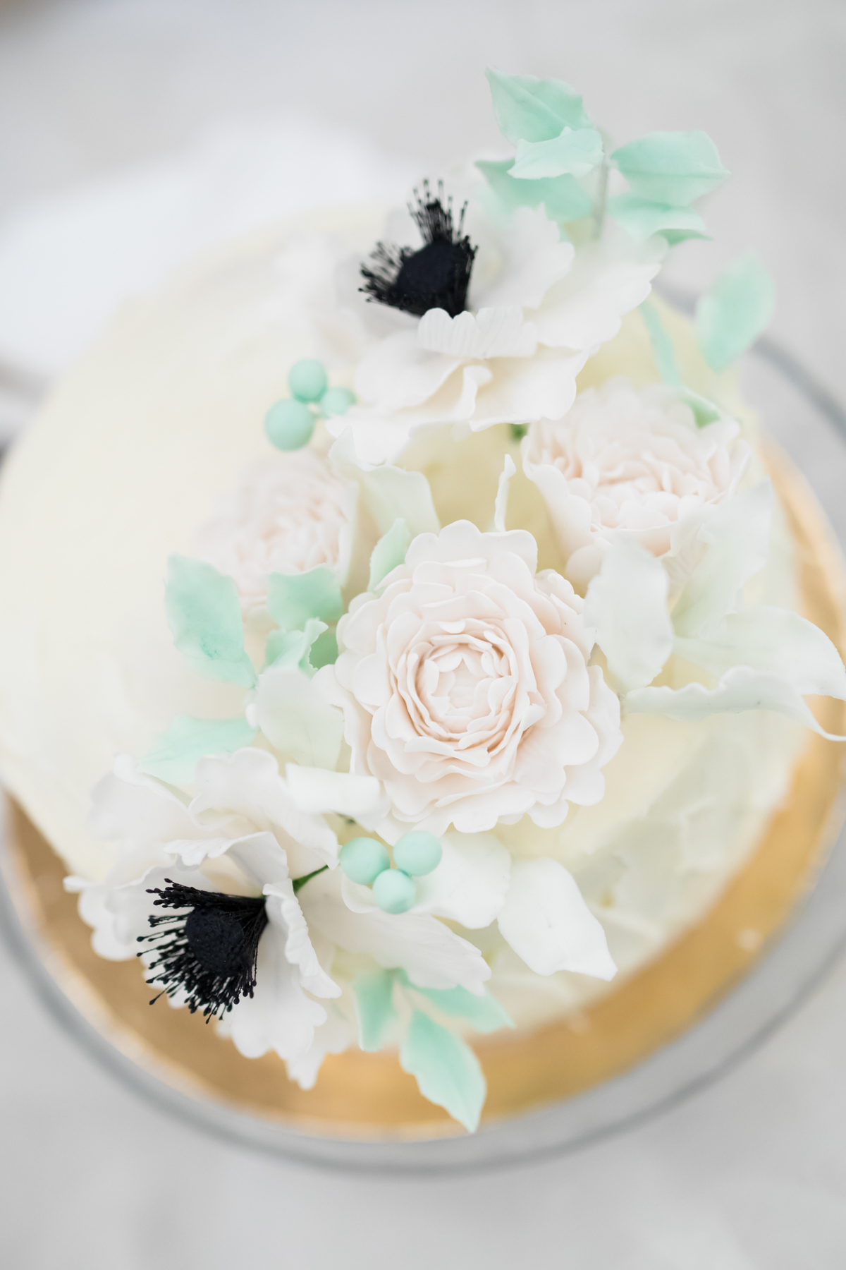 Elegant white cake decorated with beautiful sugar flowers and leaves