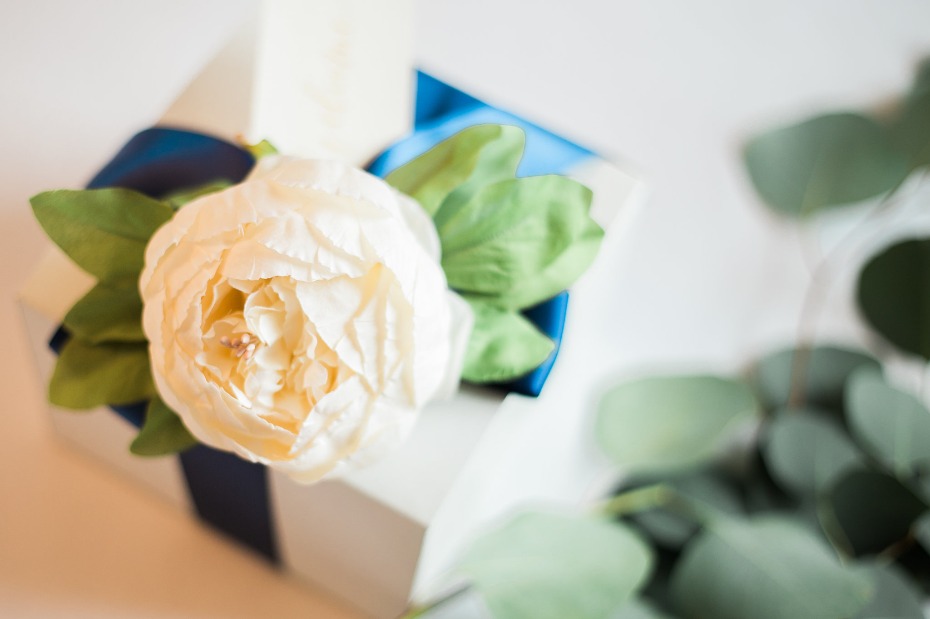 White peony adorned gift box with blue ribbon