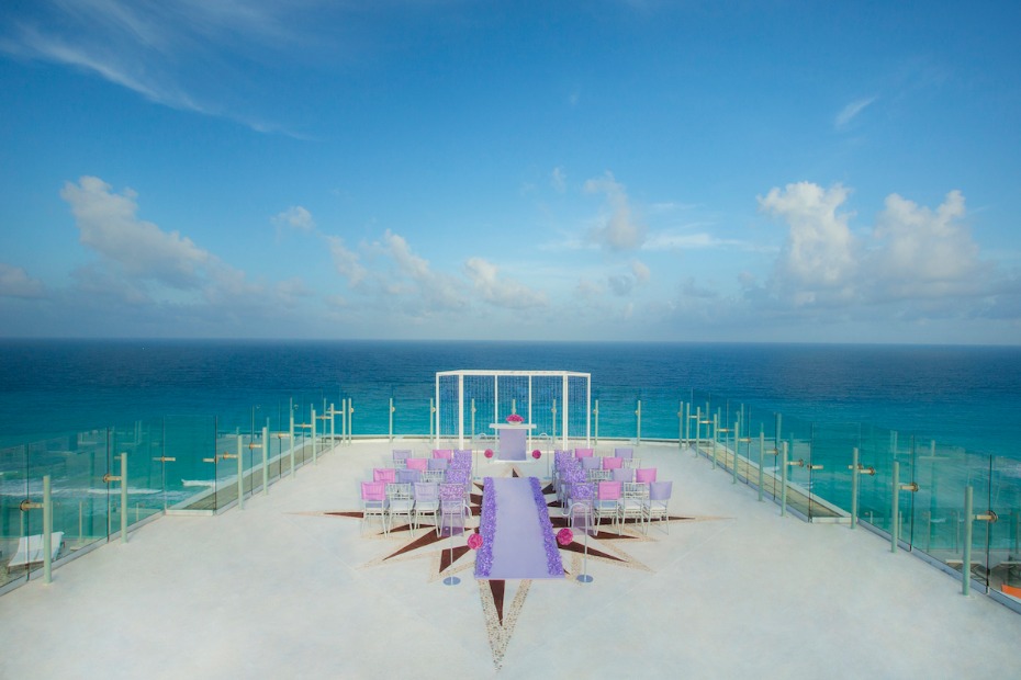Oceanfront wedding ceremony setup with purple aisle runner