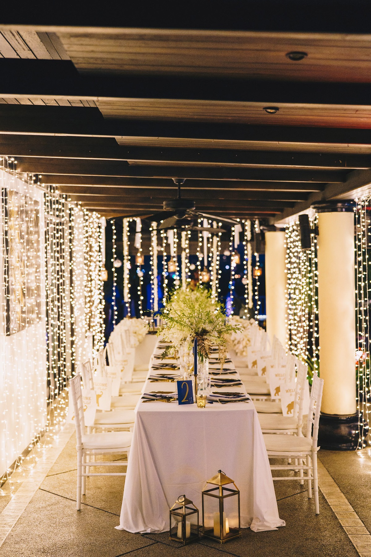 Elegant outdoor wedding table decorated with string lights at night
