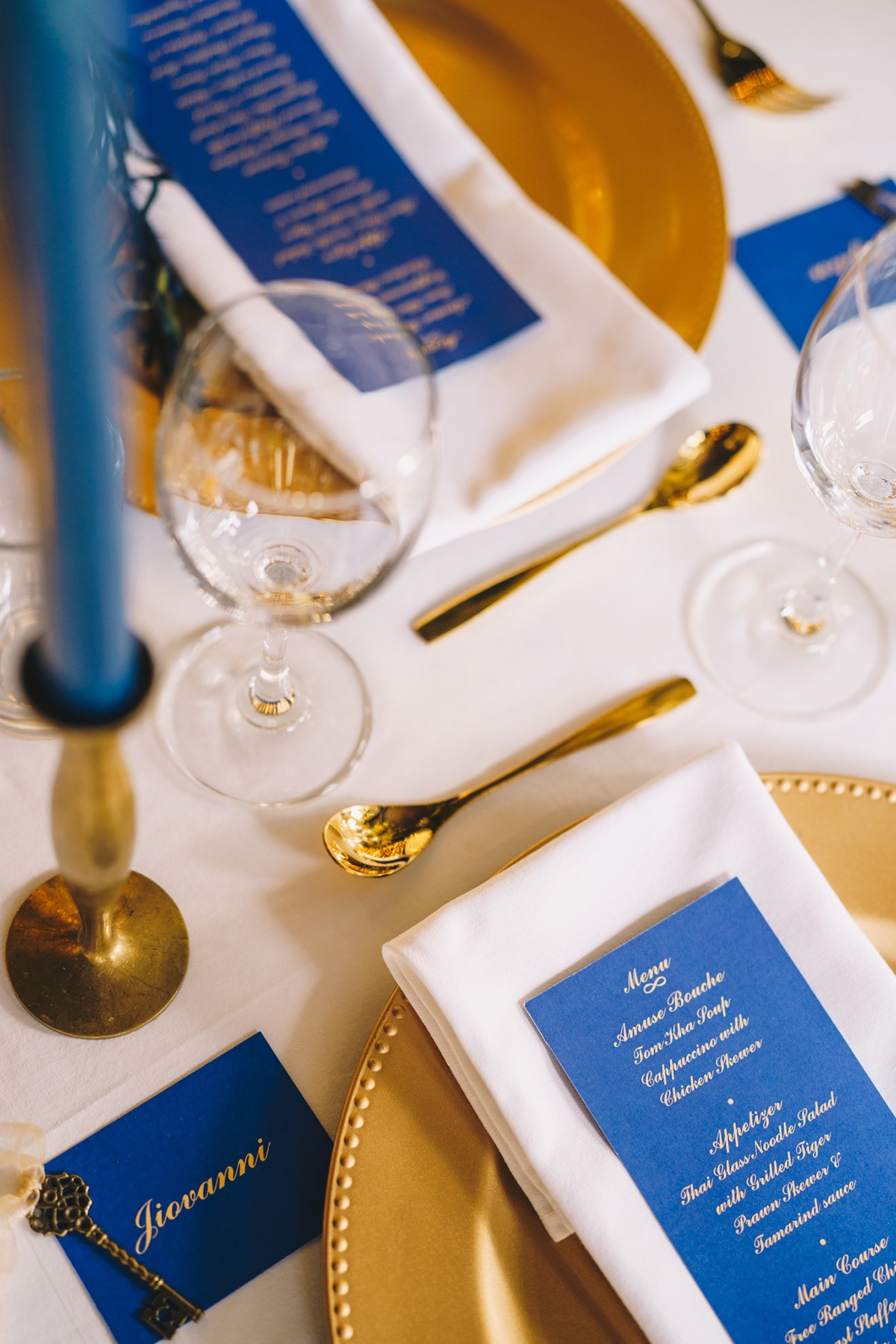 Elegant table setting with gold accents and blue menu cards