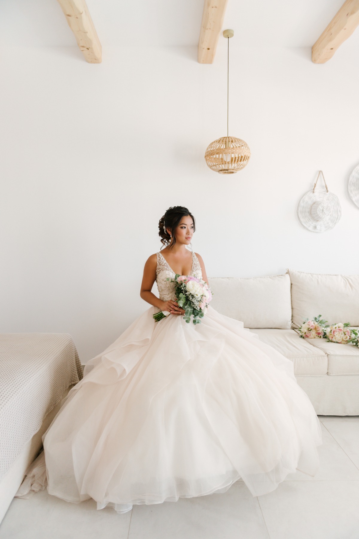 Bride in a layered tulle wedding gown holds a bouquet
