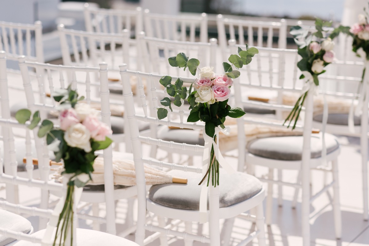 Wedding aisle chairs with pink and white floral decor